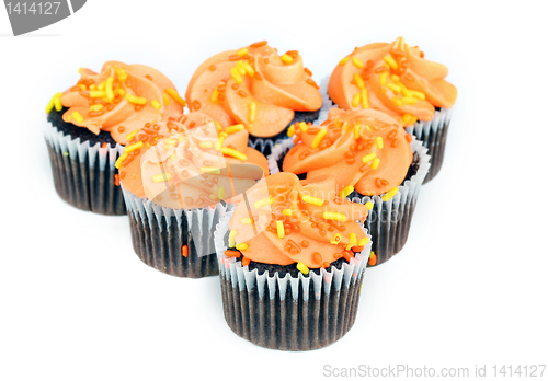 Image of Chocolate cupcakes with orange icing on white with copy space.