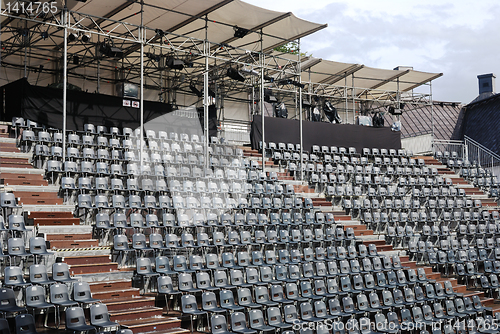 Image of rows of empty black plastic seats 