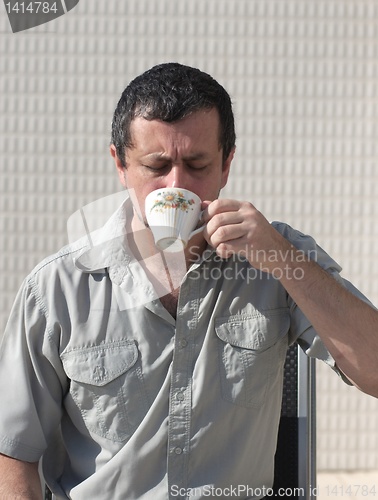 Image of business man at morning drinks coffee