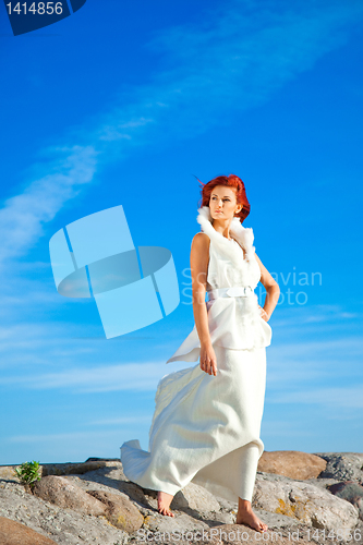 Image of  beautiful woman  in white on seacoast 