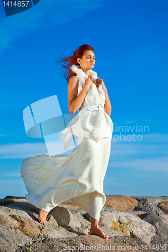 Image of  beautiful woman  in white on seacoast