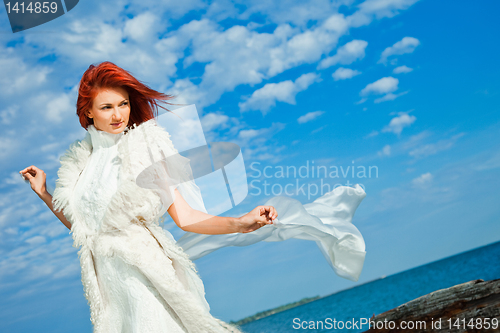 Image of  beautiful woman  in white on seacoast