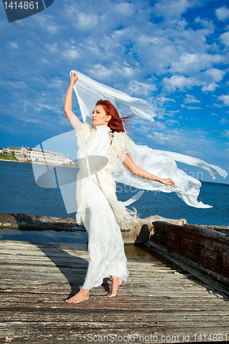 Image of  beautiful woman  in white on seacoast