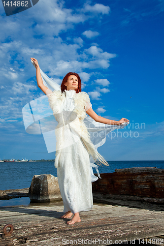 Image of  beautiful woman  in white on seacoast