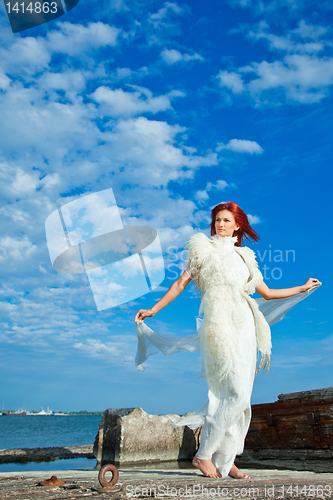 Image of  beautiful woman  in white on seacoast