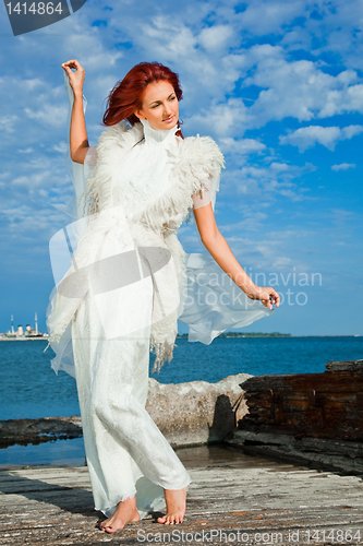 Image of  beautiful woman  in white on seacoast