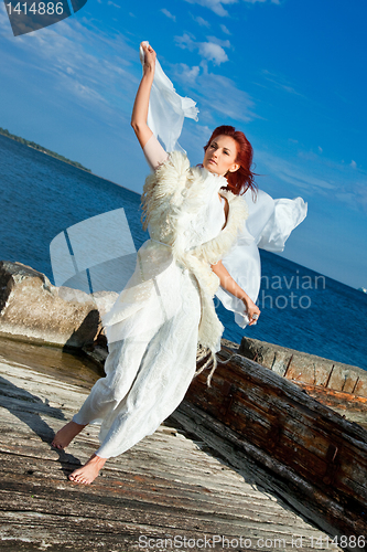 Image of  beautiful woman  in white on seacoast