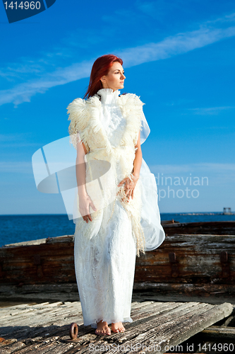 Image of  beautiful woman  in white on seacoast