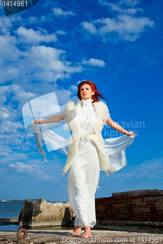 Image of  beautiful woman  in white on seacoast