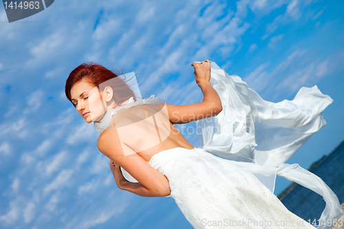 Image of  beautiful woman  in white on seacoast