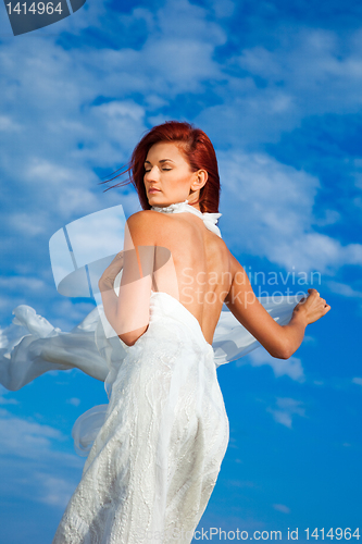 Image of  beautiful woman  in white on seacoast