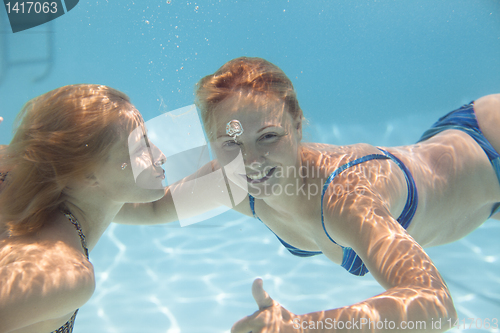 Image of young woman swimming  Under wate rwith joy