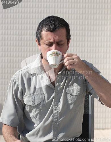 Image of business man at morning drinks coffee