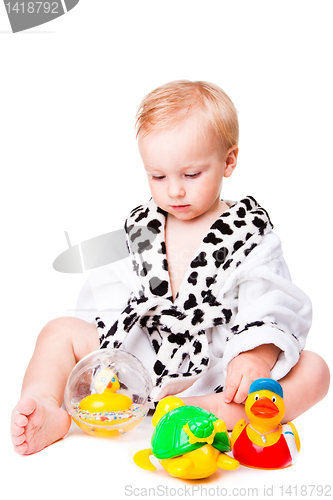 Image of baby boy playing with  toys after bathing