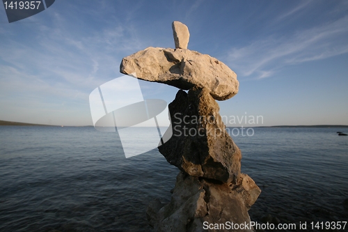 Image of Cross, rocks stacked one one top of another on beach