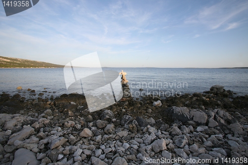 Image of Cross, rocks stacked one one top of another on beach