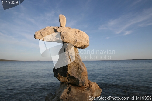 Image of Cross, rocks stacked one one top of another on beach