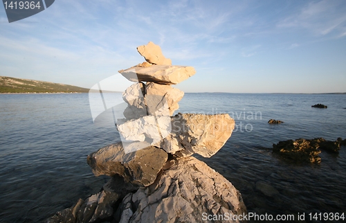 Image of Cross, rocks stacked one one top of another on beach