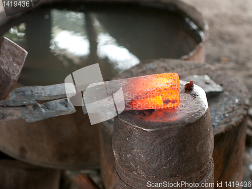 Image of Red hot head of ax at a blacksmith's workshop