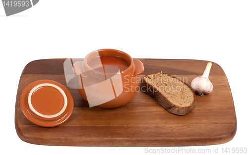 Image of Borsch with bread and garlic on wooden kitchen board