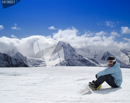 Image of Snowboarder resting on the ski slope