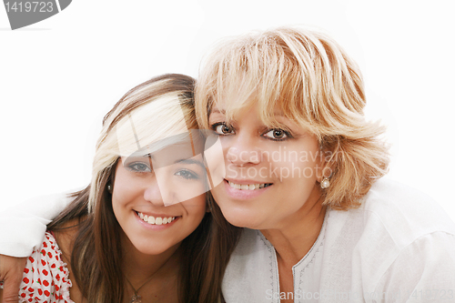 Image of mother and attractive young daughter smiling happily, looking at