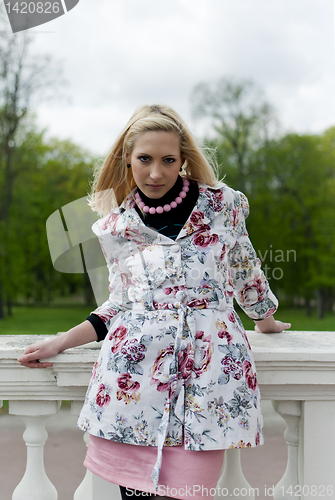 Image of blonde girl is leaning on railing