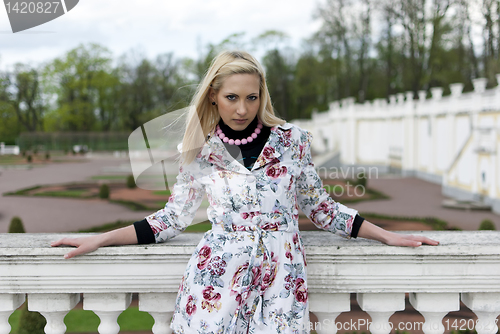 Image of blonde girl is leaning on railing