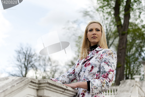 Image of blonde girl is leaning on railing