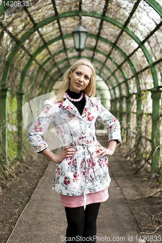 Image of blonde girl standing in an alley in the park