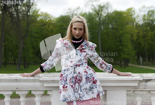 Image of blonde girl is leaning on railing