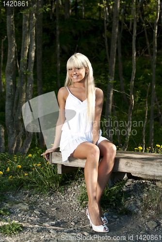 Image of girl sitting on a bench in the woods
