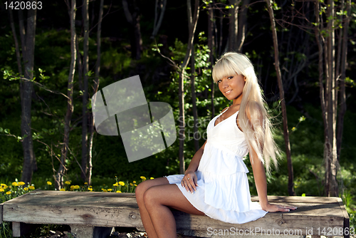 Image of girl sitting on a bench in the woods