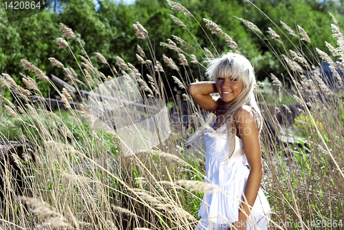 Image of girl are standing in dry grass