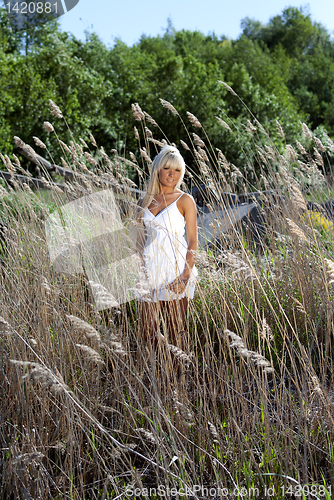 Image of girl are standing in dry grass