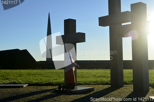 Image of Girl praying at the Crosses at sunset