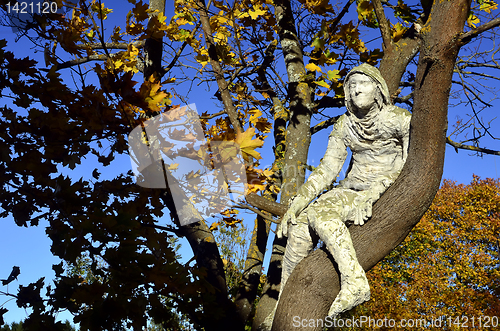 Image of man of plaster sitting on a tree