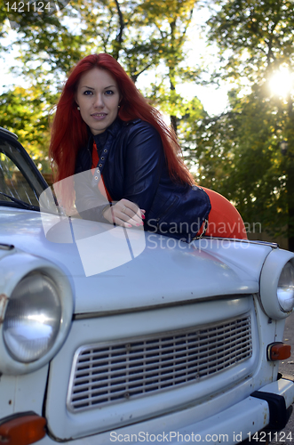 Image of redheaded girl near the old car