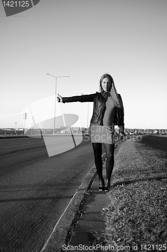 Image of girl on the road waiting for a car, black and white photo