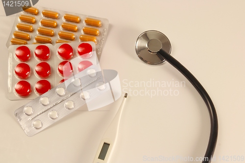 Image of Pills, thermometer and stethoscope