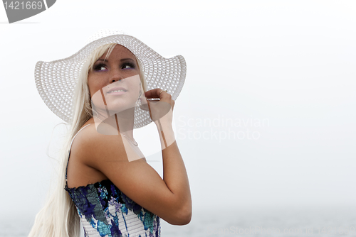Image of Girl in hat standing in the misty sea