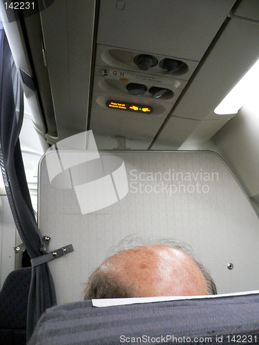 Image of Bald headed passenger on aeroplane.