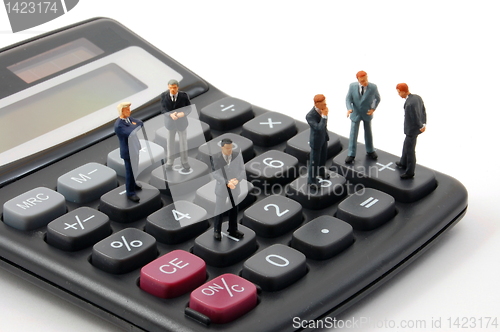 Image of toy business man on calculator isolated 