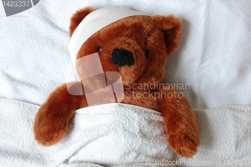 Image of sick teddy with injury in bed