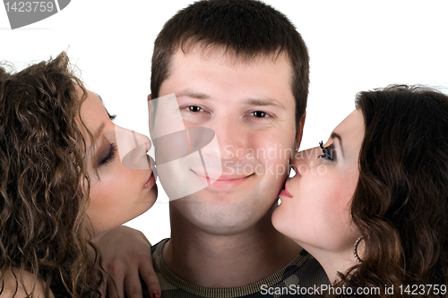 Image of Two beautiful girls kiss the young man