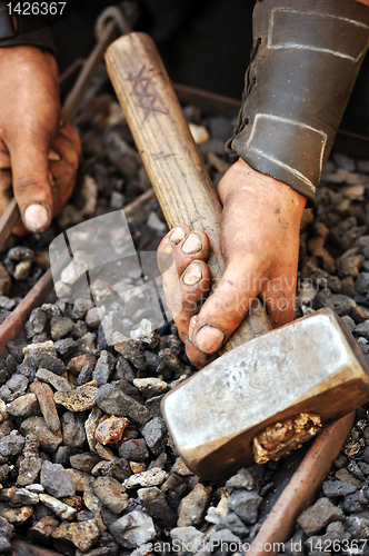 Image of Detail of dirty hands holding hammer - blacksmith