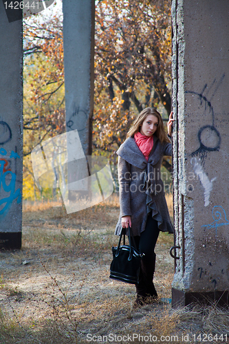 Image of Girl standing near concrete post