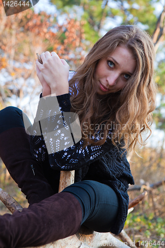 Image of Portrait of a girl sitting on a log