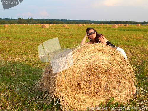Image of Girl near roll of hay.