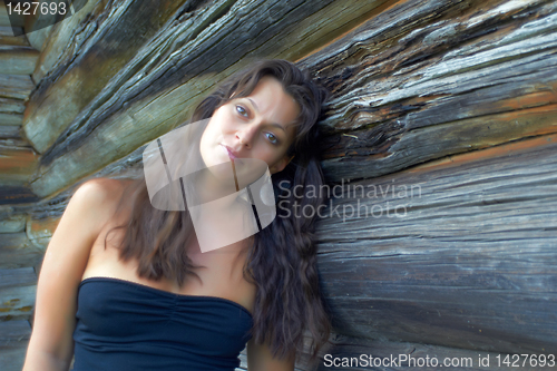 Image of Beautiful girl near the wooden wall